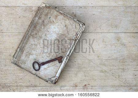 Detail of the rusty key on the old tattered book