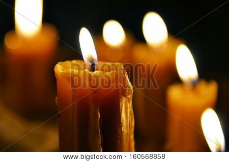 Antique candle burning in a dark room. Christmas Eve divination yuletide. Christmas backgrounds. holiday rituals religion spirituality zen. space for text close-up copy space.