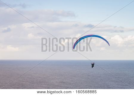 Hang glider enjoying winds high above the Pacific Ocean in Hawaii