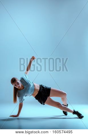 Attractive girl dancing twerk iat the blue studio background