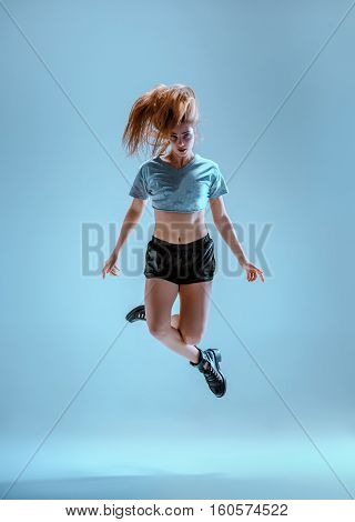 Attractive girl dancing twerk iat the blue studio background