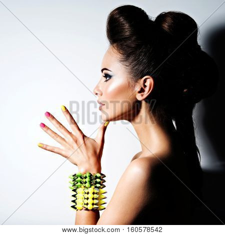 Profile portrait of a Beautiful  woman wearing bracelet with thorns and mulricolored nails
