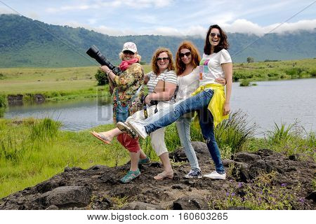 AFRICA, TANZANIA, MAY, 10, 2016 - Funny girls travellers on Africa posing for photos on a background the lake Manyara on the memory together in Ngorongoro Crater, national park Tanzania.