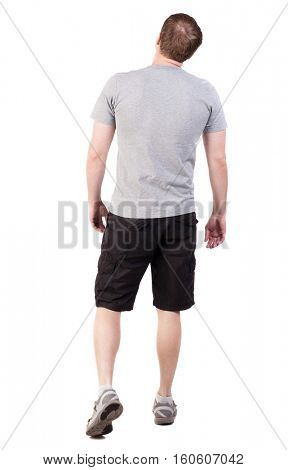 Back view of walking handsome man in shorts and sneakers.   Sports-dressed young man moves. backside view of person.  Isolated over white background. broad sporsmen in long black shorts are looking up