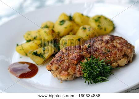 Meatballs with parsley potatoes and ketchup - closeup