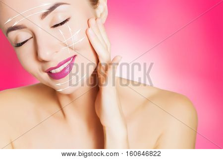 beautiful woman face with surgery marks on pink