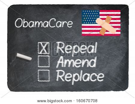 Obamacare health plan choice for repeal written in chalk on a chalky natural slate blackboard isolated against white background
