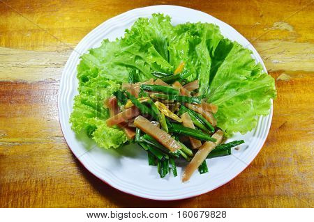stir fried pickled crispy squid with garlic chives and lettuce on plate