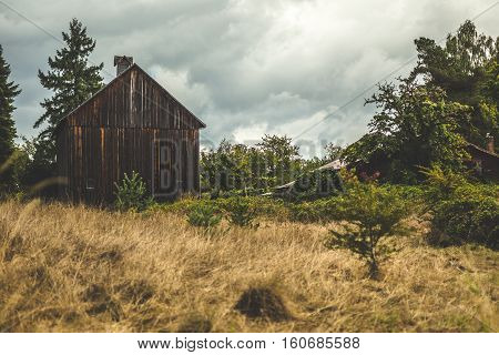 Small, old, brown barn in the countryside. Cloudy summer or fall setting. Beaverton, Oregon, USA.