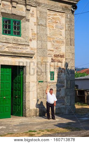 O PEDROUZO SPAIN - AUGUST 15: Man ring the bell of the Santa Eulalia church on August 15 2016