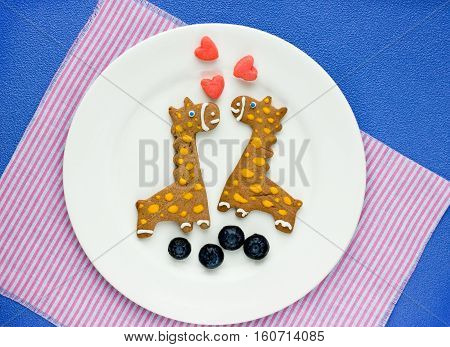 Creative cookies for kids in the form of a giraffe with fresh berries on breakfast