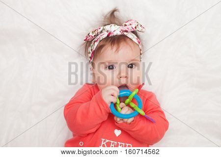5 months old lovely baby portrait on white with teether toy