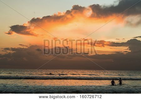 Beautiful sunset of Kuta Beach Bali Indonesia. Silhouettes of people at sunset on Kuta beach in Bali Indonesia