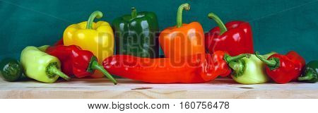 Close-up image of colorful display of edible peppers on wood board.