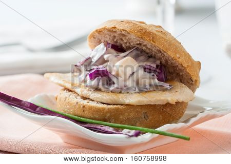 Streetfood: delicious chicken and cabbage sandwich on a plate.