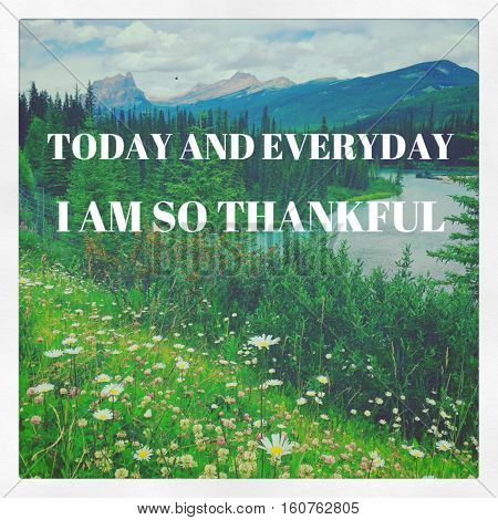 nspirational quote on scenic summer mountain landscape with blue sky and white clouds over rocky mountain peaks.Trees, river and wildflowers in foreground.Instagram effects.