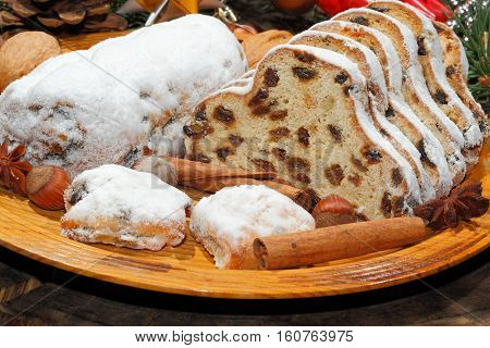 Christmas stollen with Christmas decoration on a wooden plate