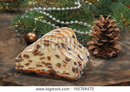 Christmas stollen with Christmas decoration on a wooden plate