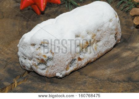 Christmas stollen with Christmas decoration on a wooden plate