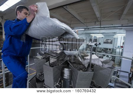 Worker Working On The Machine For Packing Loose Food