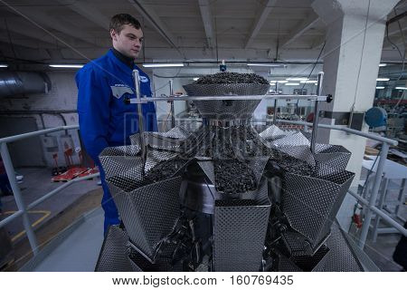 Worker Working On The Machine For Packing Loose Food