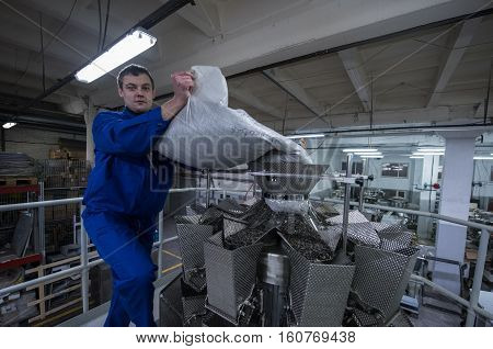 Worker Working On The Machine For Packing Loose Food