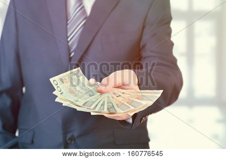 Range of Polish banknotes in hand. businessman giving money loan polish zloty pln hand concept