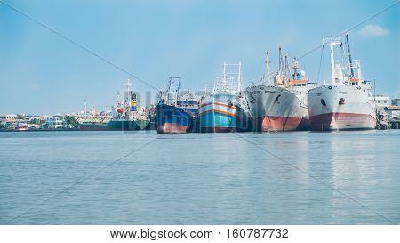 Many boats moored alongside the home Fishing boats with blue sky.