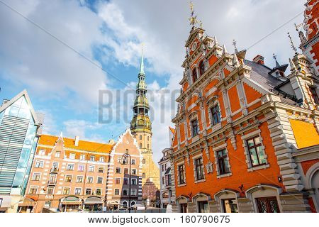 View on the central square with famous houses of Blackheads and cathedral tower in Riga city, Latvia