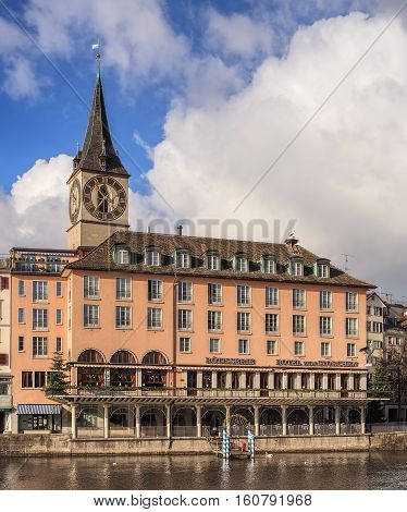 Zurich Switzerland - 26 November 2013: Hotel Storchen building clock tower of the St. Peter Church in the background. Hotel Storchen is a traditional first class establishment with 66 rooms and suites in the old town of the city.