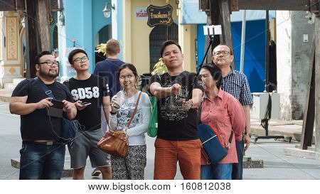 PHUKET THAILAND SEPTEMBER 27: Tourists selfie at the walking street among old building Chino Portuguese style on street of Phuket town Thailand on September 27 2016.