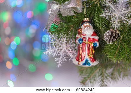 Christmas composition toy hanging on fir branch on a background of beautiful bokeh
