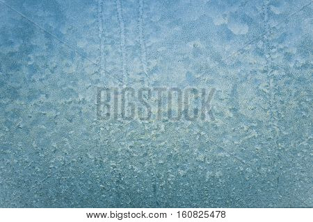 frost and ice patterns on windowglass coverd with ice