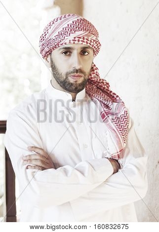Young smiling handsome arabian man wearing traditional clothes