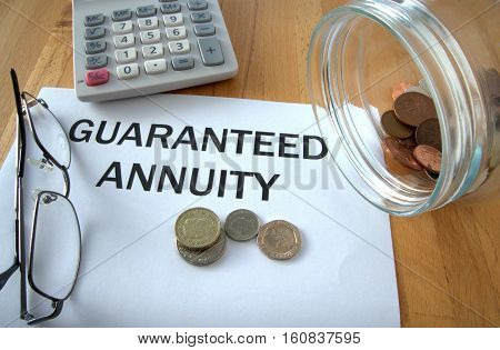Guaranteed Annuity with coins on paper and in pot and calculator behind