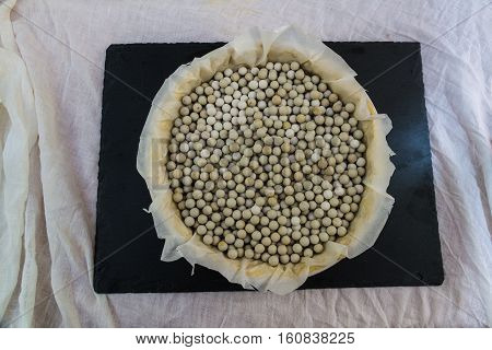 Baking Beans Lining A Flan Dish On Table Top.