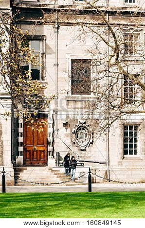Dublin Ireland - April 4 2010: Two young women stand on the steps of an old building on campus of the Trinity College Dublin.