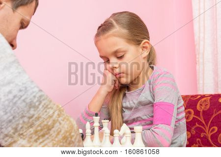 Seven-year Daughter Is Thinking About The Next Move, Playing Chess