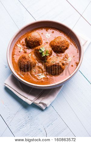 malai kofta curry - classic North Indian dish. vegetarian alternative to meatballs served with tandoori roti or indian bread and green salad, selective focus