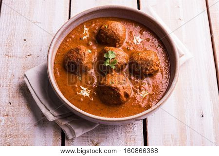 malai kofta curry - classic North Indian dish. vegetarian alternative to meatballs served with tandoori roti or indian bread and green salad, selective focus