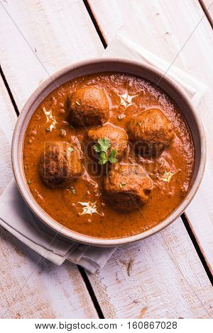 malai kofta curry - classic North Indian dish. vegetarian alternative to meatballs served with tandoori roti or indian bread and green salad, selective focus