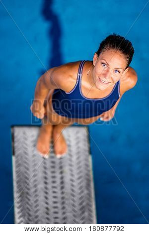 Female Diver Standing On The Jumping Board.