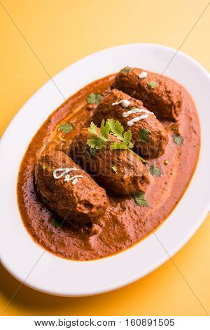 malai kofta curry - classic North Indian dish. vegetarian alternative to meatballs served with tandoori roti or indian bread and green salad, selective focus