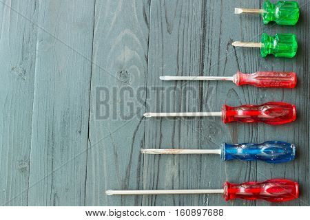 Many screw drivers on black wooden background. Screwdriver to remove the devices.