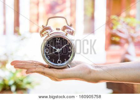 Time and priorities conceptual image.Clock on hand