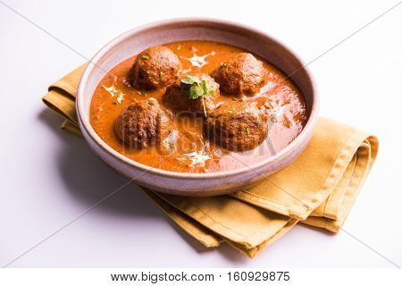 malai kofta curry - classic North Indian dish. vegetarian alternative to meatballs served with tandoori roti or indian bread and green salad, selective focus