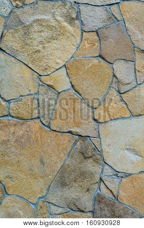 Background of a stone wall cladding texture brown stone bricks