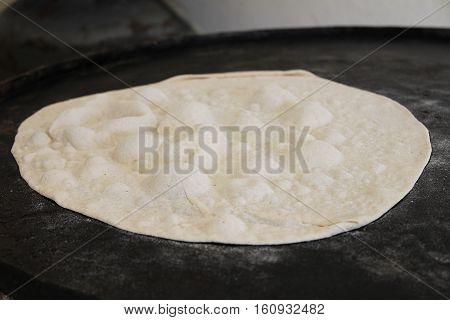 A slice of dough baked on the Lebanese traditional saj to become pita bread.
