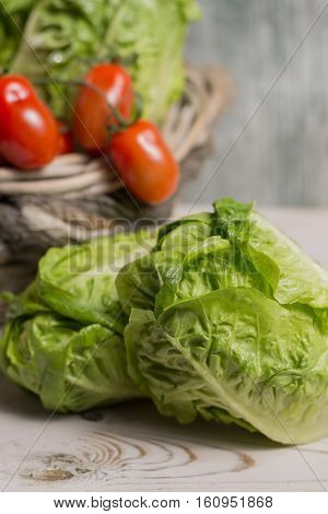 Ingredients for fresh spring healthy green salad. Green fresh roma lettuce salad leaves and roma mini tomatoes - healthy low calorie food