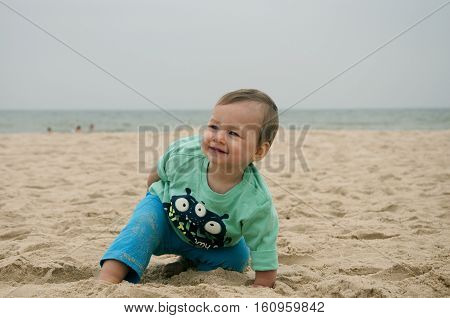 cheerfull baby playing in sand on vacations, summer trip.